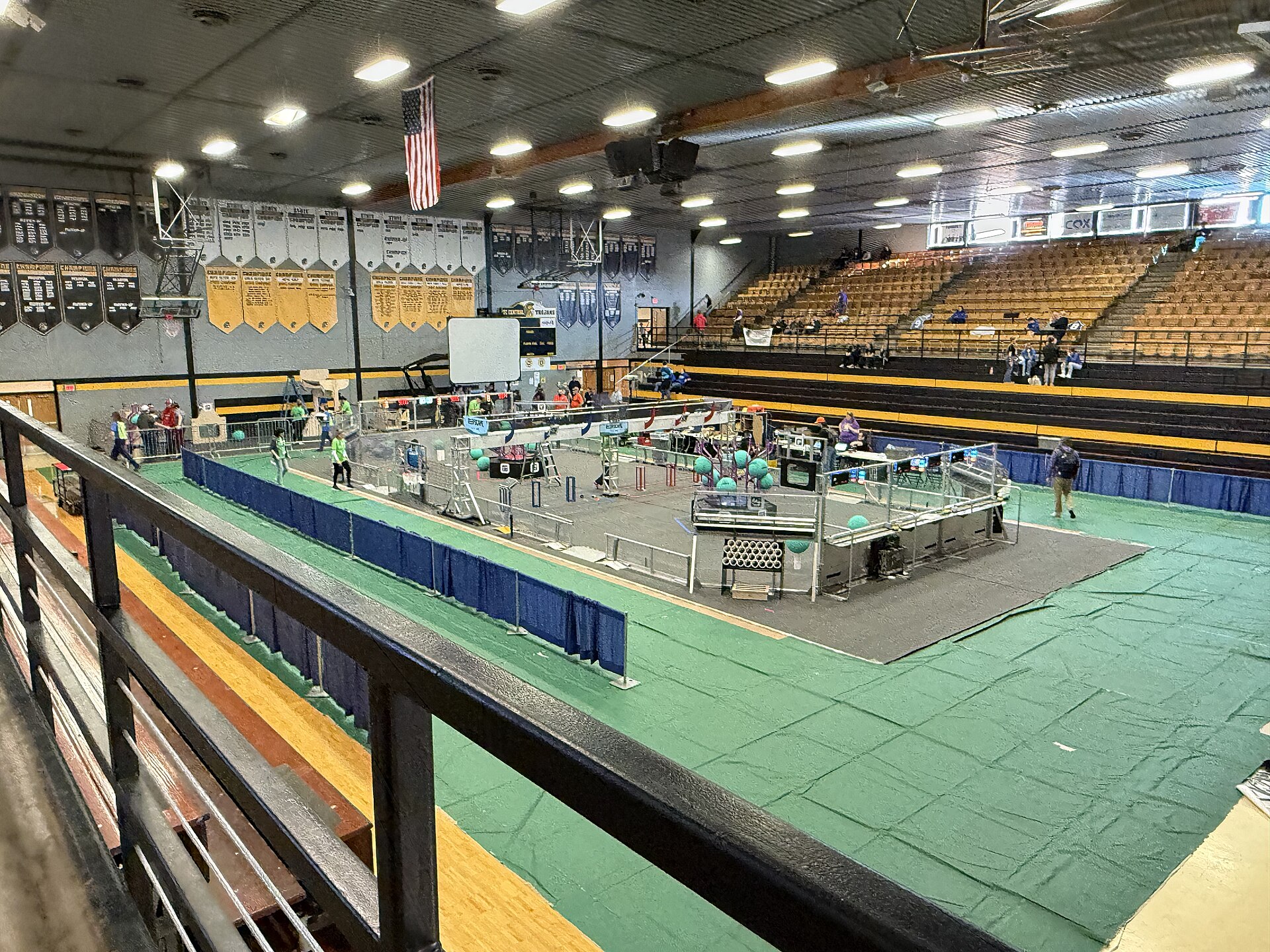 An FRC field set up in a gym, with robots, game pieces and the driver stations